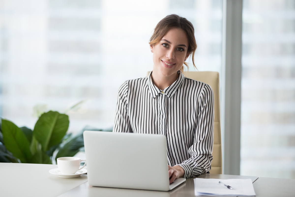 Head shot portrait of confident businesswoman at workplace