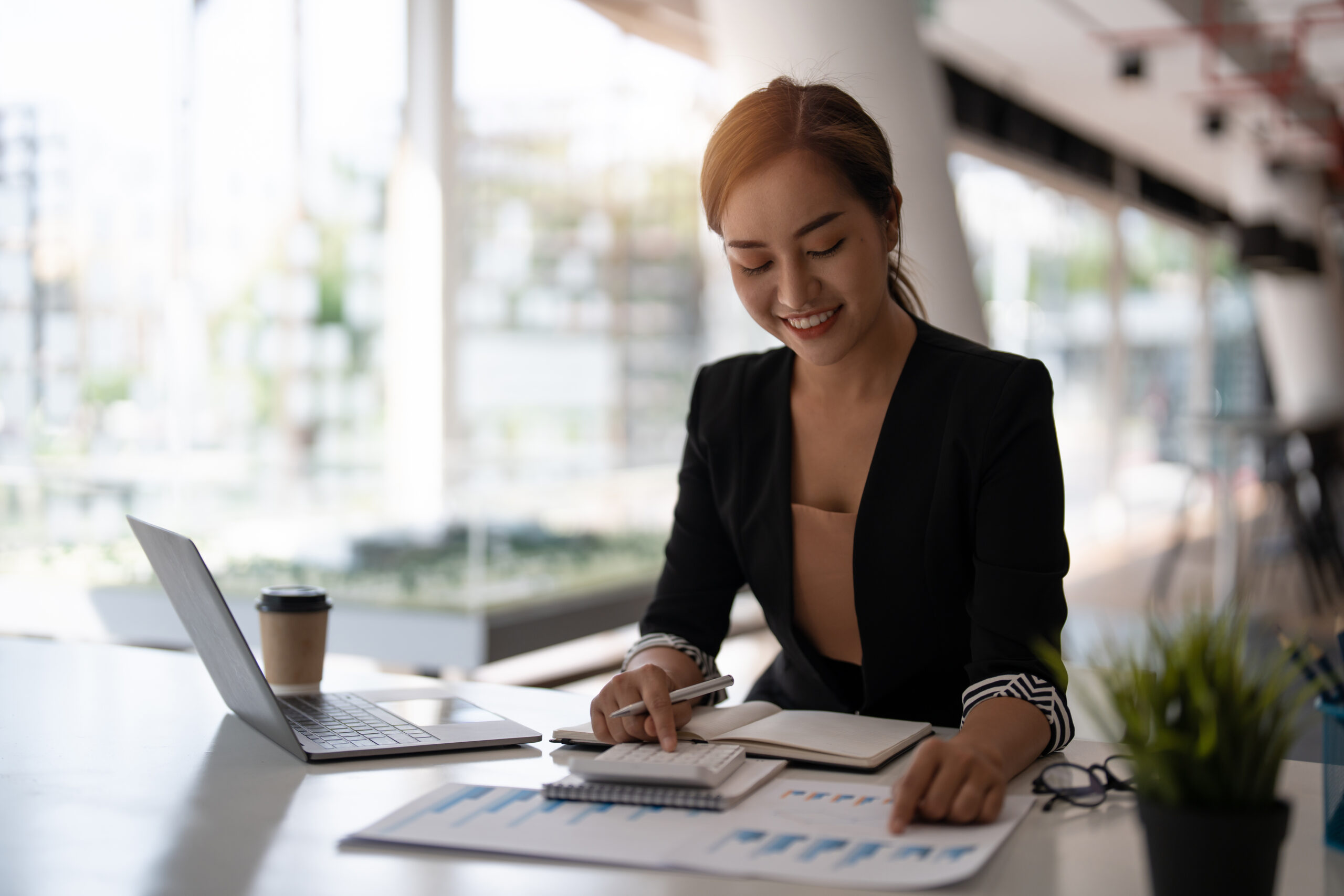 Happy asian businesswoman working for financial marketing with calculator at modern office