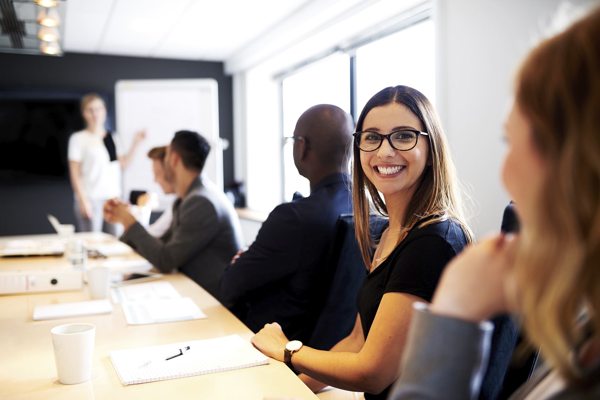 Female executive smiling at camera during work presentation