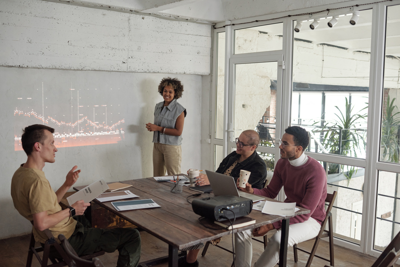 Group of young contemporary economists discussing rates during preentation