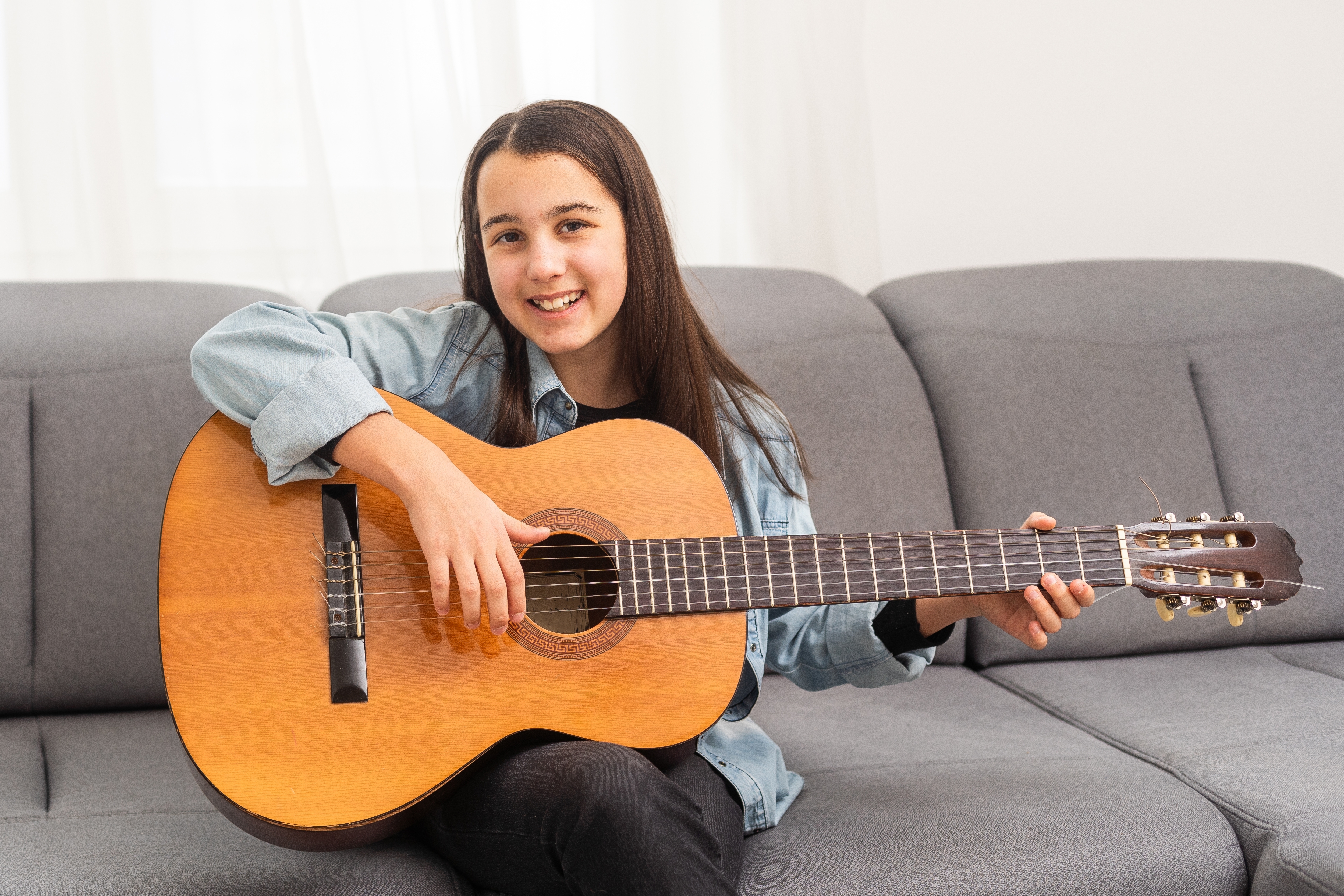 Portrait,Of,Smiling,Teen,Student,Practicing,Guitar,During,Music,Lessons