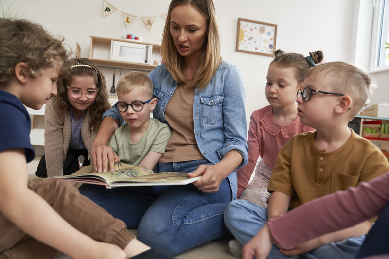 Teacher and pupils reading book together